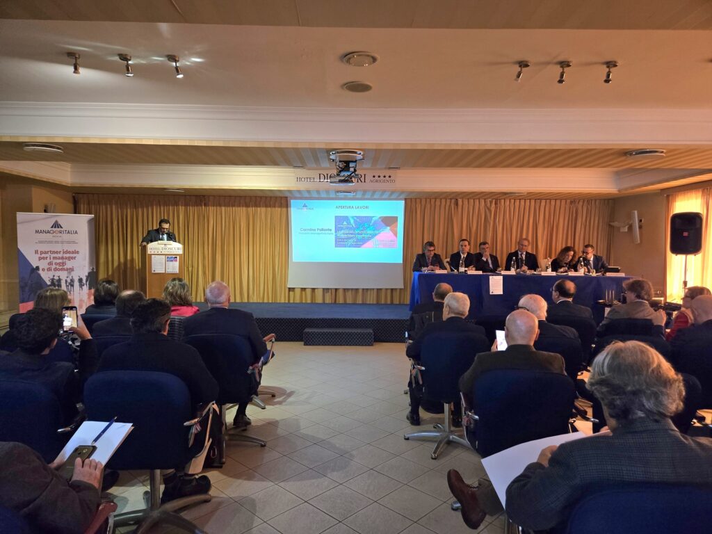 sala convegno con persone sedute che ascoltano un relatore al podio