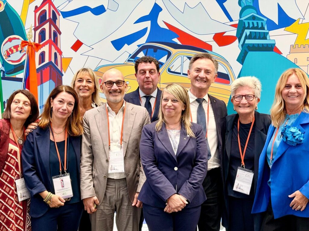 gruppo di ersone di manageritalia davanti a un muro colorato